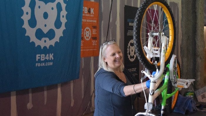 smiling woman fixing bikes